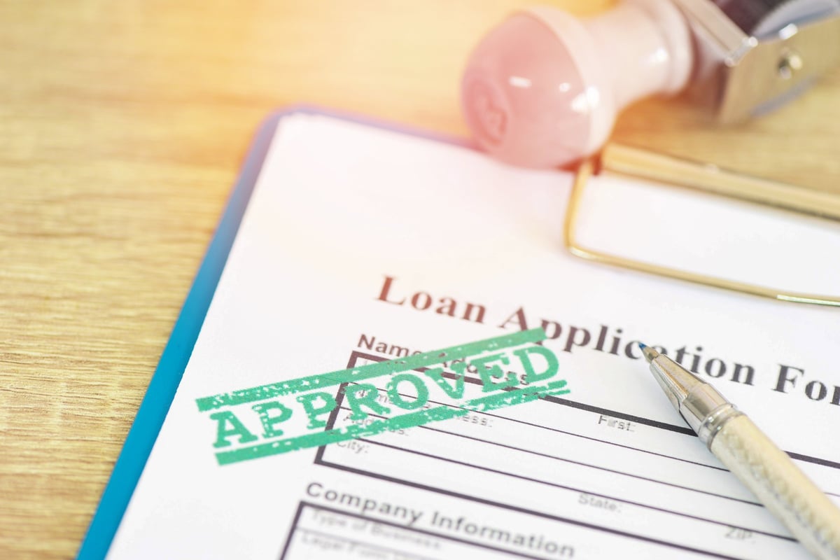 Loan approval application form with rubber stamp, contract money and document