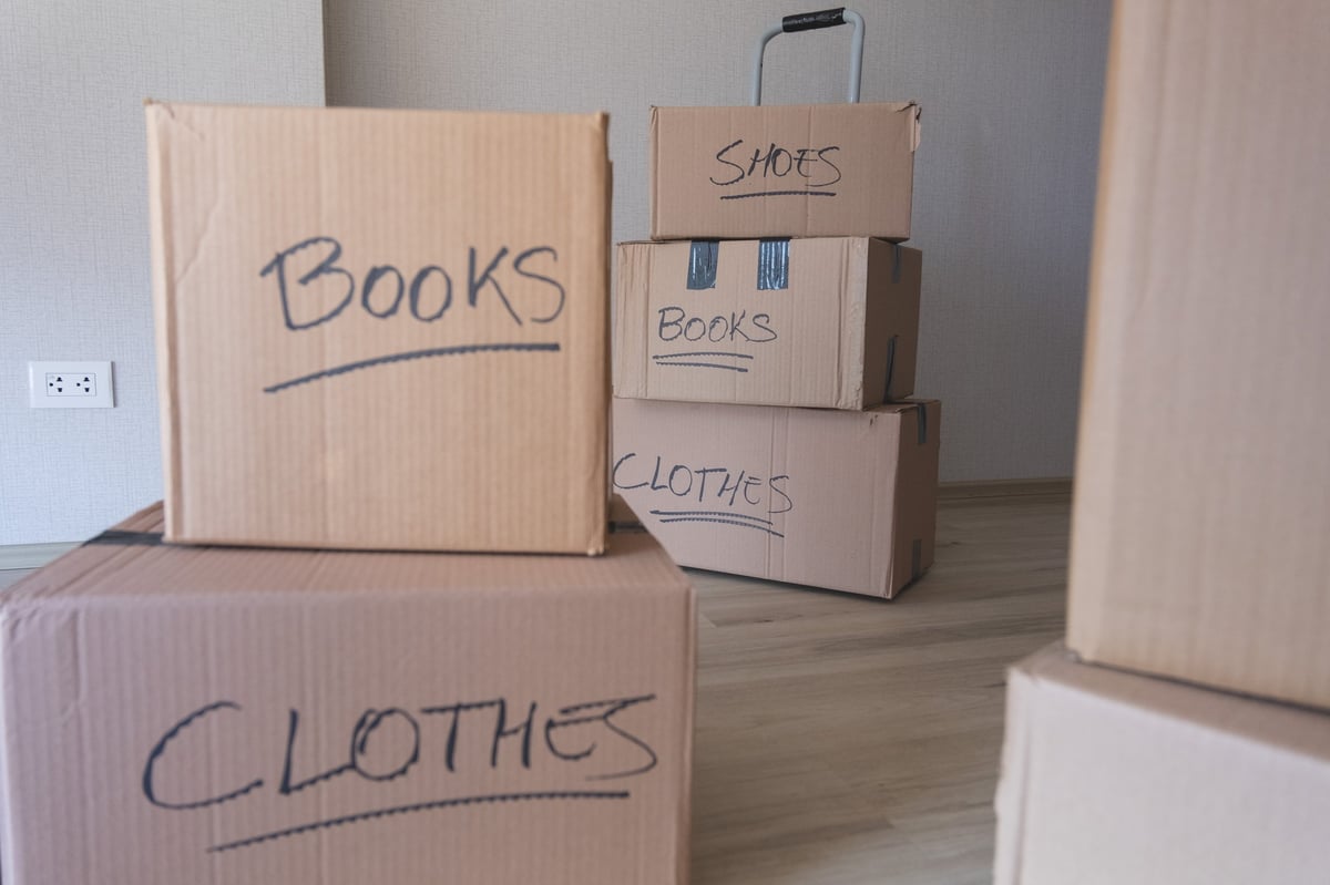 A stack of boxes with the words books and clothes written on them being packed for a move