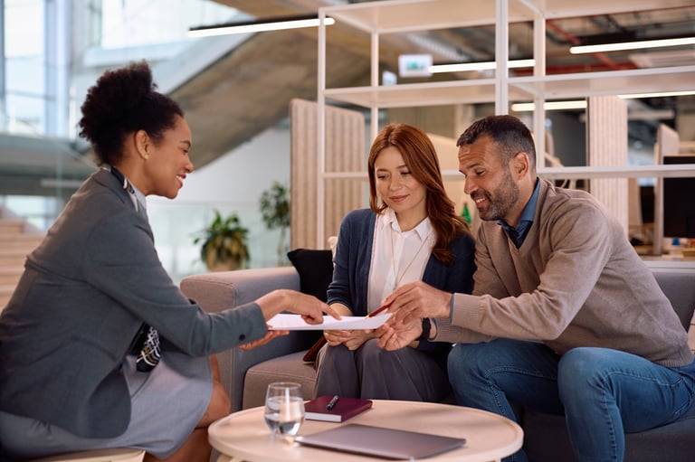 Happy couple with financial advisor signing contract