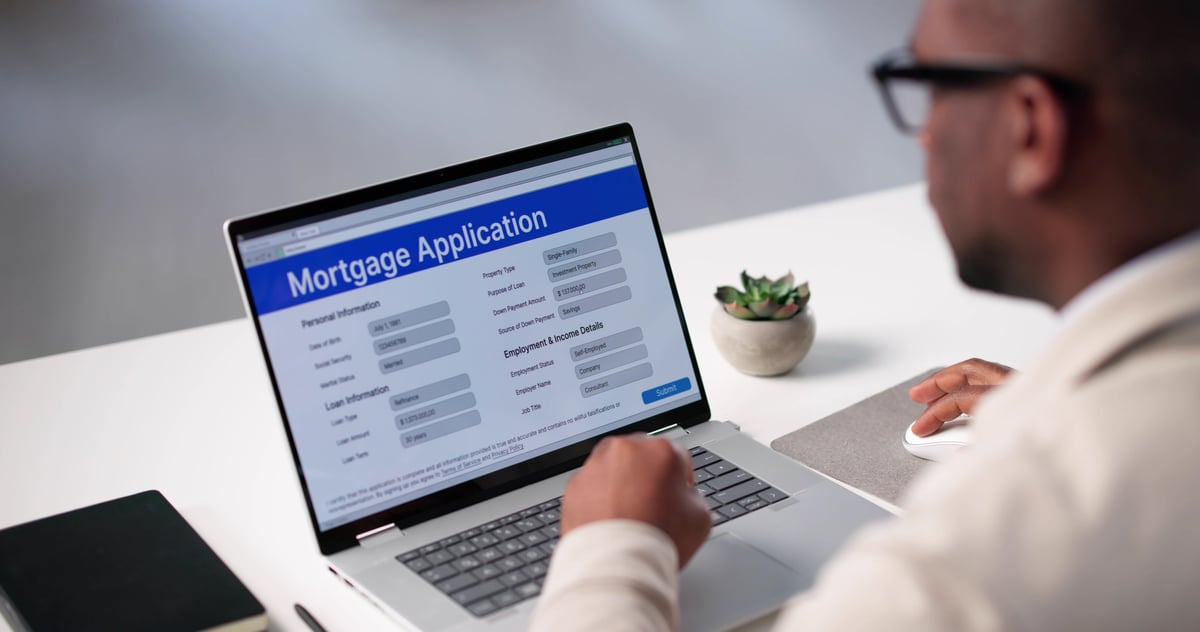 Real estate broker filling out a mortgage application on a laptop computer online