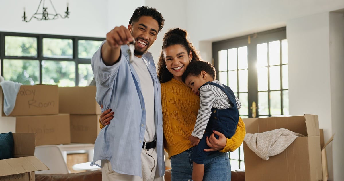 Happy family with keys in a new home in the living room, mortgage approval and real estate