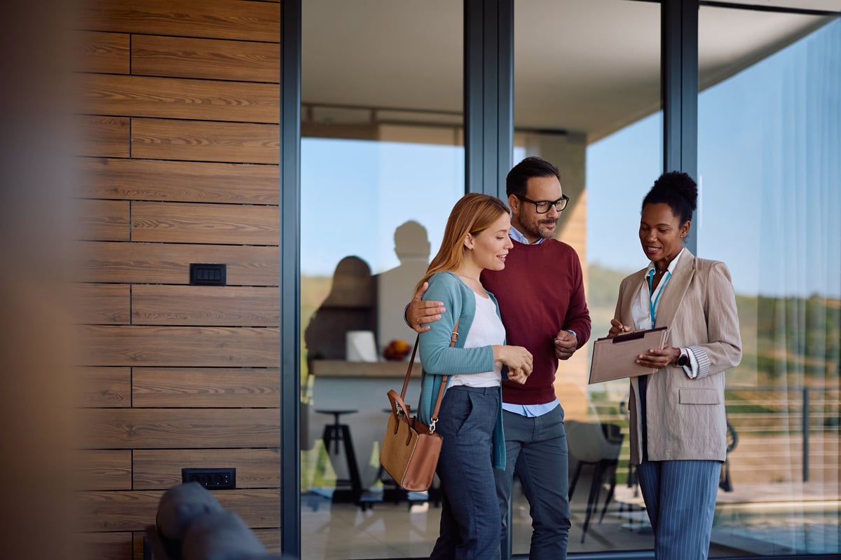 African American real estate agent going through housing plans with a couple buying a new home