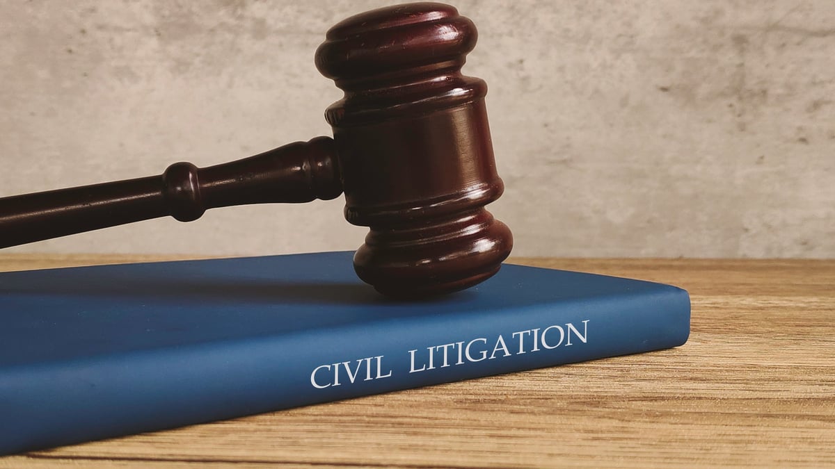 Gavel and a book titled CIVIL LITIGATION on a wooden table symbolizing justice and legal process