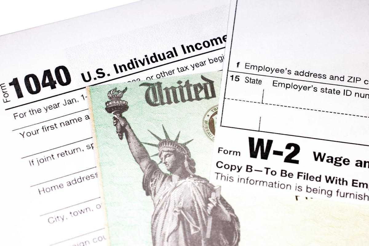 Tax return with refund check and W-2 wage statement with shallow depth of field