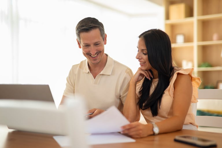 Happy couple discussing financial planning while reviewing documents