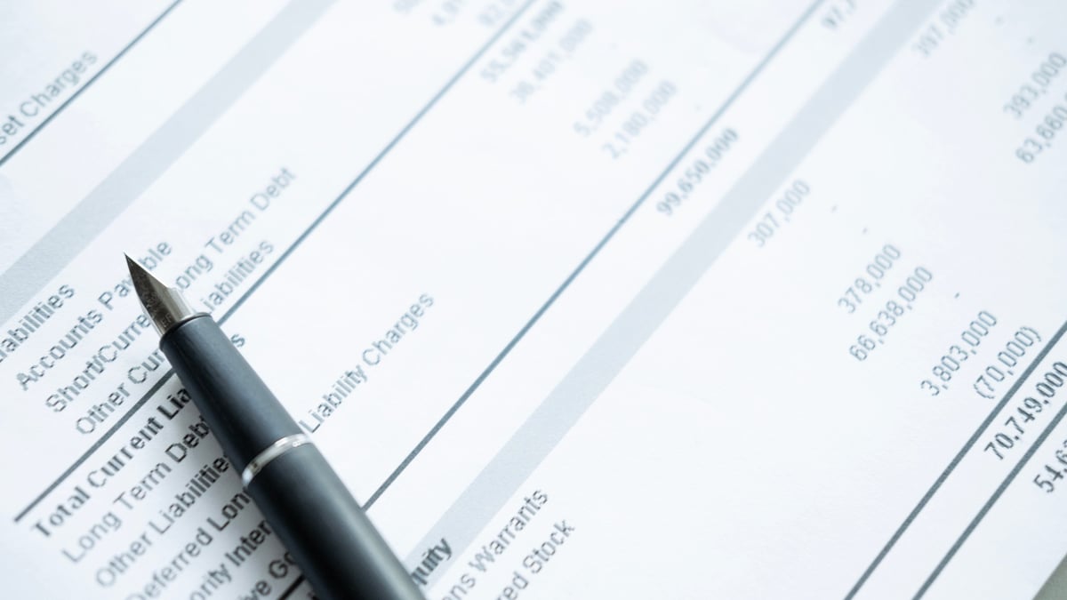 Close up of pen on the liabilities section of a financial statement, debt analysis and accounting review concept