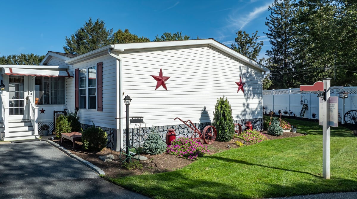 A house standing in a suburban area surrounded by a well-kept garden with red stars exterior bright under the sun