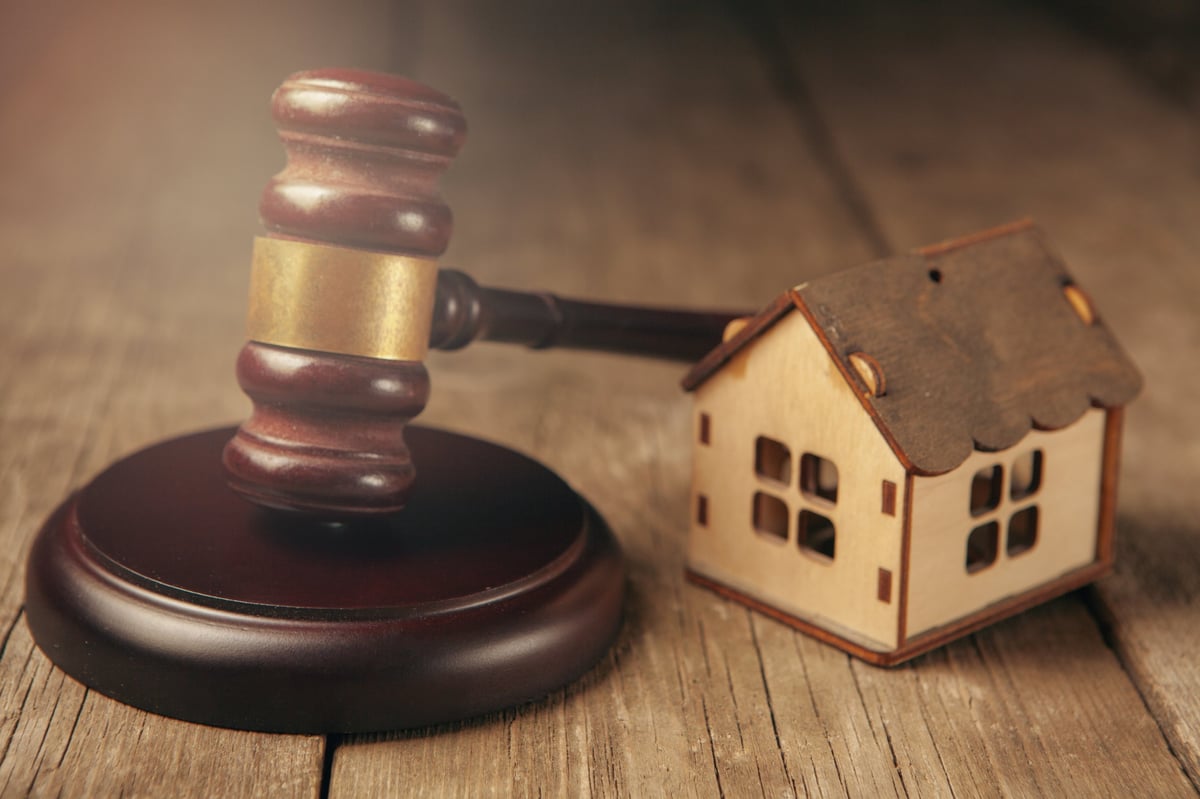 Wooden gavel and house on wooden background real estate concept